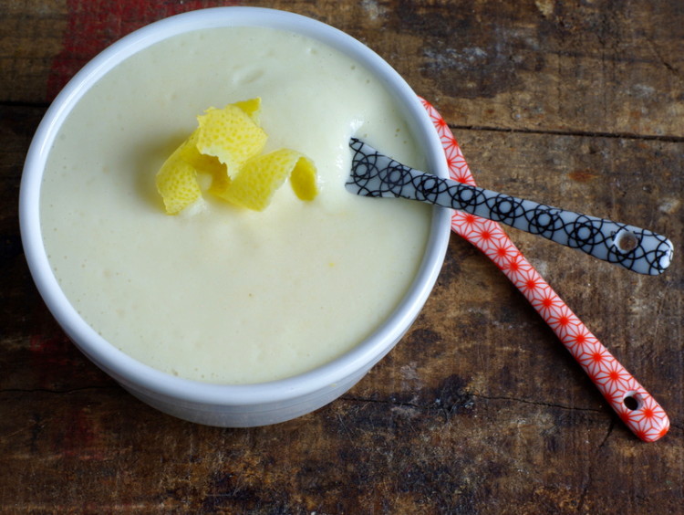 Small bowl of creamy pudding with a strip of lemon zest on top