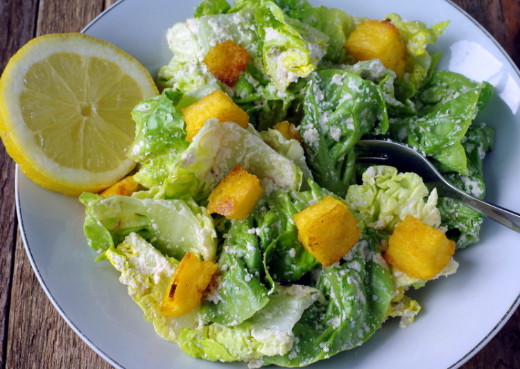Crisp ceasar salad with golden croutons and a slice of lemon